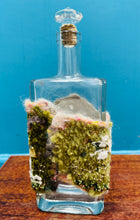 Load image into Gallery viewer, Gwaith ffelt a gwnio wedi ei wneud â llaw a’i lapio am botel wydr / Handmade felt and sewing work wrapped around a glass bottle
