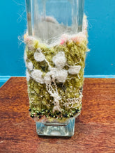Load image into Gallery viewer, Gwaith ffelt a gwnio wedi ei wneud â llaw a’i lapio am botel wydr / Handmade felt and sewing work wrapped around a glass bottle