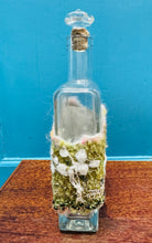 Load image into Gallery viewer, Gwaith ffelt a gwnio wedi ei wneud â llaw a’i lapio am botel wydr / Handmade felt and sewing work wrapped around a glass bottle