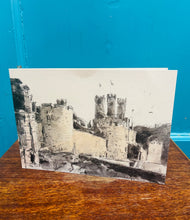 Load image into Gallery viewer, Cardyn print ‘Muriau Tref Caernarfon’ William Selwyn wedi ei arwyddo gyda pen inc gan yr artist a’i wraig wedi ei fframio / Framed William Selwyn ‘Muriau Tref Caernarfon’ card signed with an ink pen by the artist and his wife
