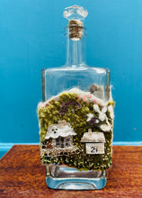 Load image into Gallery viewer, Gwaith ffelt a gwnio wedi ei wneud â llaw a’i lapio am botel wydr / Handmade felt and sewing work wrapped around a glass bottle
