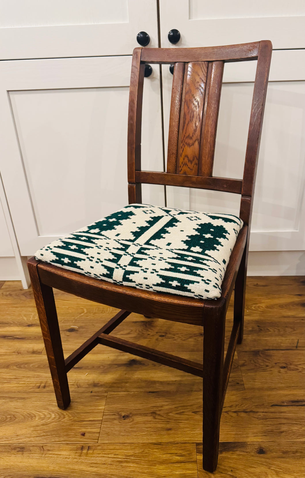 Cadair dderw ‘Chanchellor’ o 1960 wedi’i orchuddio gyda Blanced Brethyn Cymreig hufen a gwyrdd tywyll / 
‘Chanchellor’ oak chair from 1960 covered in a cream and dark green Welsh Tapestry blanket