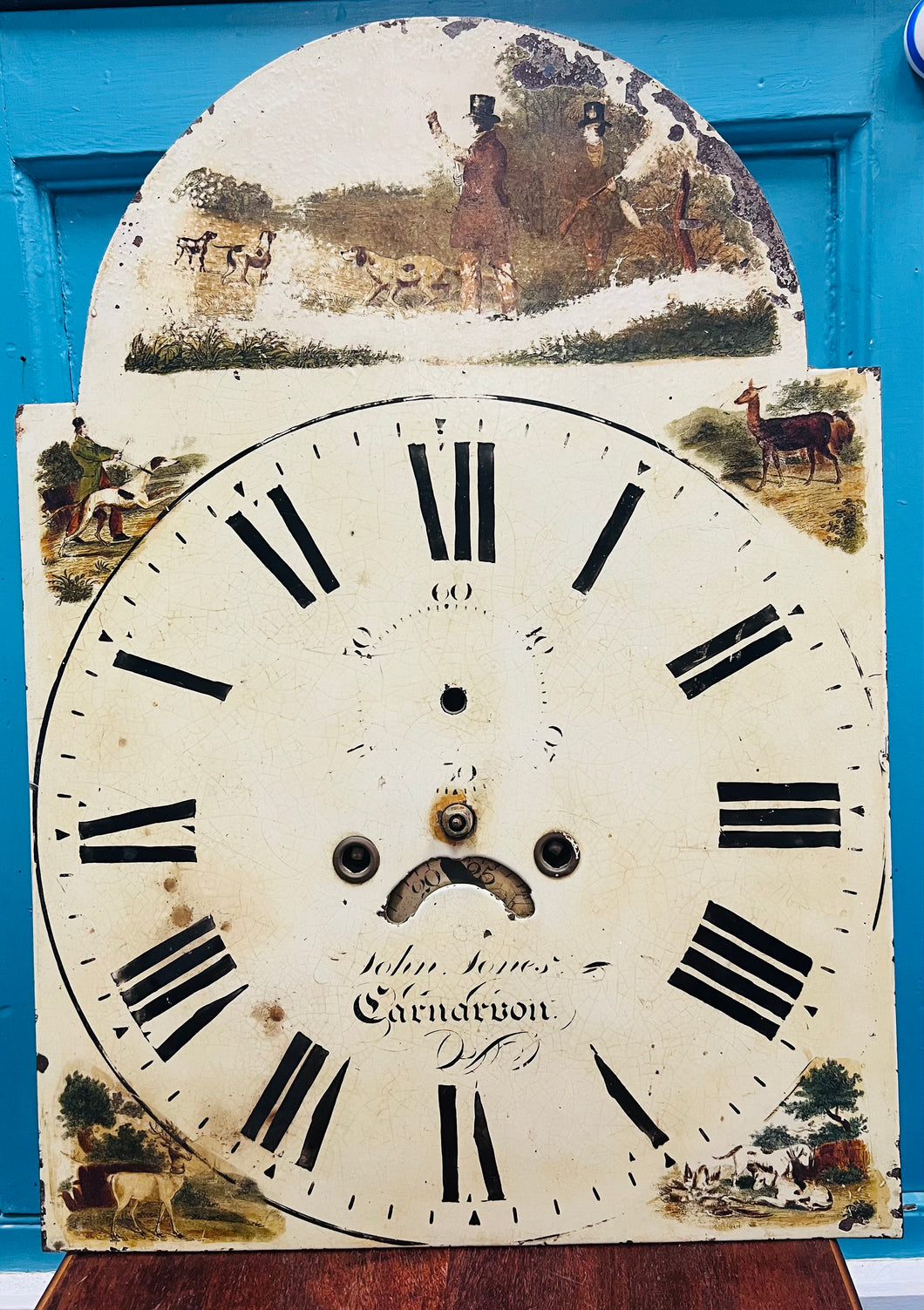 Wyneb cloc Taid Hynafol gyda golygfa helfa arno gan John Jones o Gaernarfon (1828-1844) / Antique John Jones Caernarfon Grandfather clock face with a hunting scene on it (1828-1844)